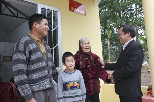 Trưởng Phòng LĐTB&XH Vũ Đức Chánh chia sẻ niềm vui với mẹ Đào Thị Hải bên ngôi nhà tình nghĩa mới được xây dựng.