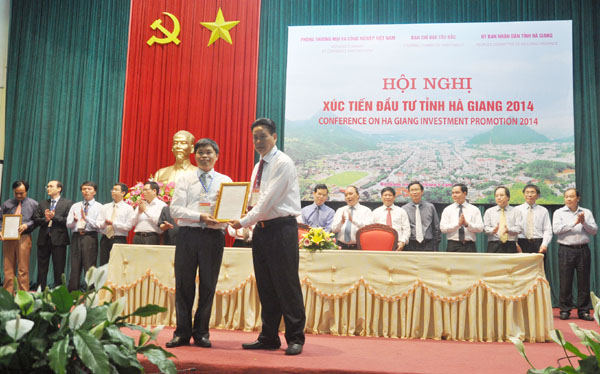 Phó Chủ tịch Thường trực UBND tỉnh Nguyễn Văn Sơn trao Giấy chứng nhận đầu tư Nhà máy Tuyển luyện quặng Ăng - ti - mon 2 (Mậu Duệ - Yên Minh) cho Công ty Cổ phần Cơ khí & Khoáng sản tại Hội nghị Xúc tiến Đầu tư tỉnh Hà Giang năm 2014. Ảnh VĂN NGHỊ