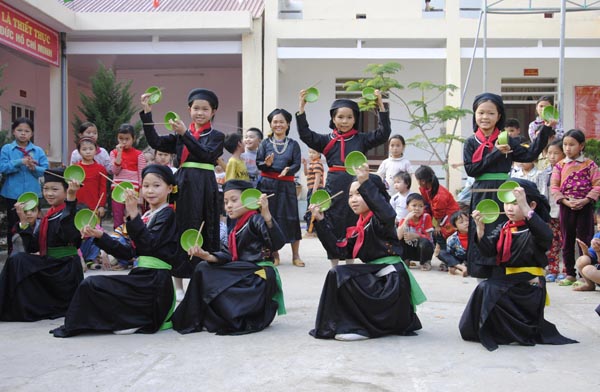 Học sinh Trường Tiểu học Nà Chì được các nghệ nhân dạy múa bát (bài múa truyền thống của người Tày) trong buổi học ngoại khóa.
