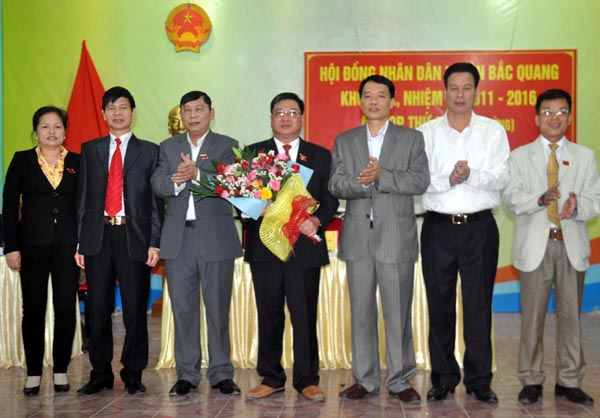 Phó Chủ tịch Thường trực UBND tỉnh Nguyễn Văn Sơn và Trưởng ban Tổ chức Tỉnh ủy Nguyễn Trung Tài, lãnh đạo huyện Bắc Quang tặng hoa chúc mừng đồng chí Hoàng Quang Phùng được bầu giữ chức Chủ tịch HĐND huyện Bắc Quang khóa XIX.