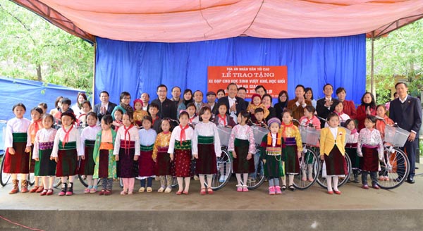 Đồng chí Trương Hòa Bình, Bí thư T.Ư Đảng, Chánh án Tòa án nhân dân tối cao tặng xe đạp cho các em học sinh trường THCS xã Sà Phìn (Đồng Văn).