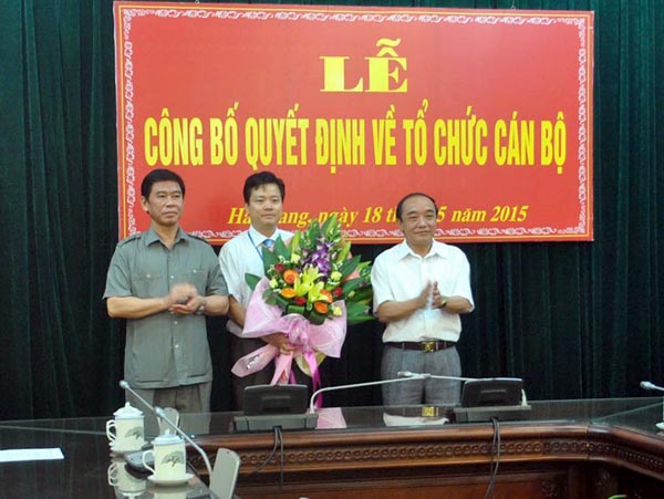 Đồng chí Vương Mí Vàng và đồng chí Đàm Văn Bông trao quyết định, tặng hoa chúc mừng đồng chí Trần Quang Minh.