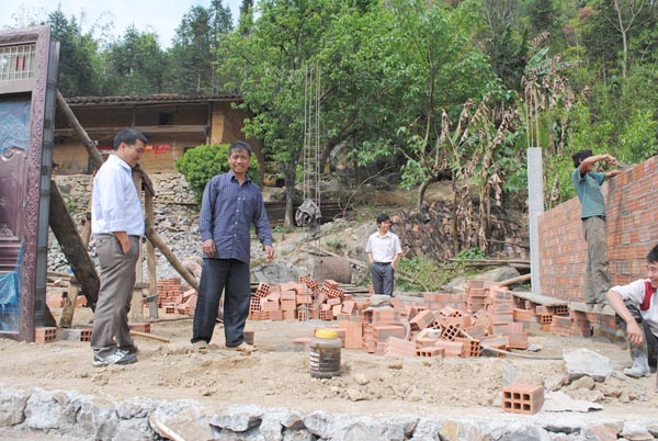Anh Lầu Chúng Nhù, người Mông ở thôn Thẻn Pả, xã Lũng Cú (Đồng Văn), bên cạnh ngôi nhà đang xây dựng sau chuyến đi làm ở Trung Quốc.