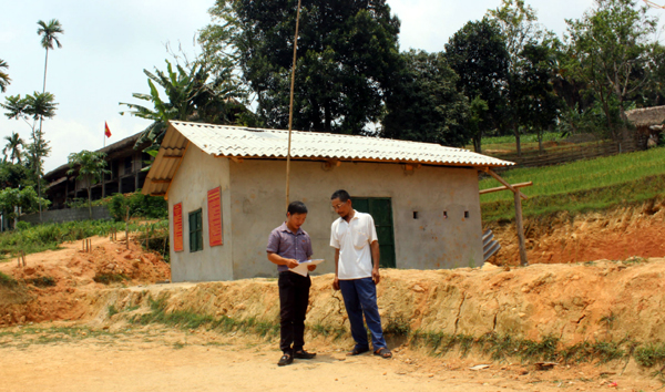 Ông Hoàng Trung Tự, thôn Xuân Hòa, trao đổi với cán bộ xã Khuôn Lùng tại khu đất rộng hơn 1.000m2 mà gia đình ông tự nguyện hiến đất vườn nhà để làm Hội trường thôn.