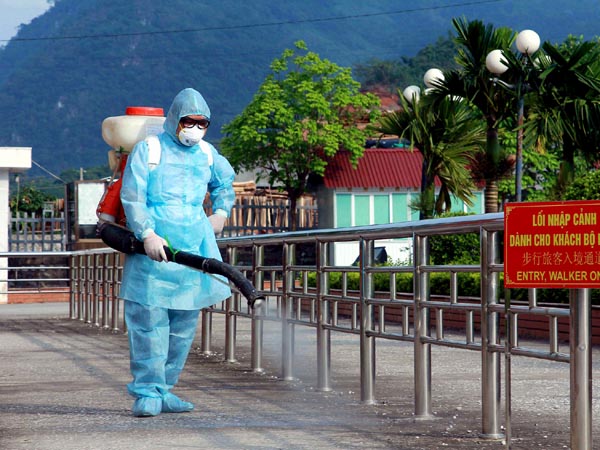 Kiểm dịch viên phun khử trùng tiêu độc tại khu vực dành cho khách  đi bộ.