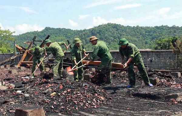 Cán bộ, chiến sĩ Ban Chỉ huy Quân sự thành phố Hà Giang giúp các hộ dân bị cháy nhà thu dọn chuẩn bị dựng lại nhà tạm.