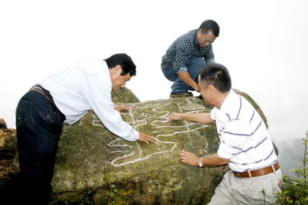 PGS.TS Trình Năng Chung (áo trắng) và đoàn khảo sát của BQL Công viên Địa chất toàn cầu - Cao nguyên đá Đồng Văn tiến hành khảo sát bước đầu những tảng đá mang hình khắc cổ.