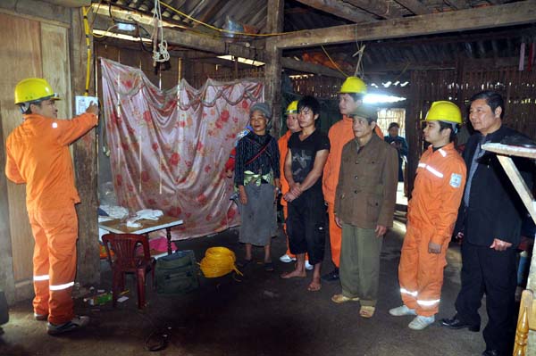 Công nhân Điện lực thành phố Hà Giang thay thế, hướng dẫn hộ gia đình ông Lộc Đức Vinh sử dụng hệ thống điện mới.