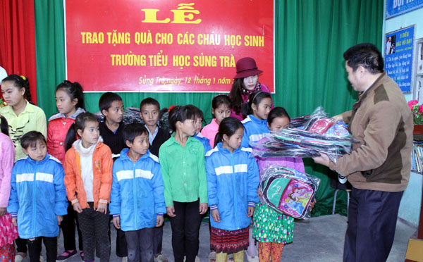 Đồng chí Sùng Mí Chứ, Phó Tổng biên tập Báo Hà Giang trao cặp sách cho các cháu học sinh Trường Tiểu học Sùng Trà, năm học 2015 – 2016.