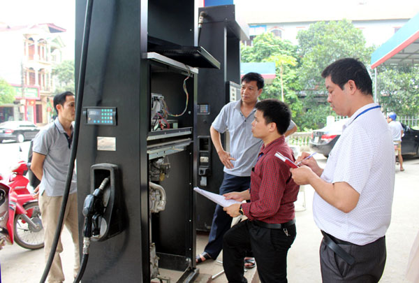 Cán bộ đo lường kiểm tra tại cột bơm Cửa hàng xăng dầu Minh Khai.