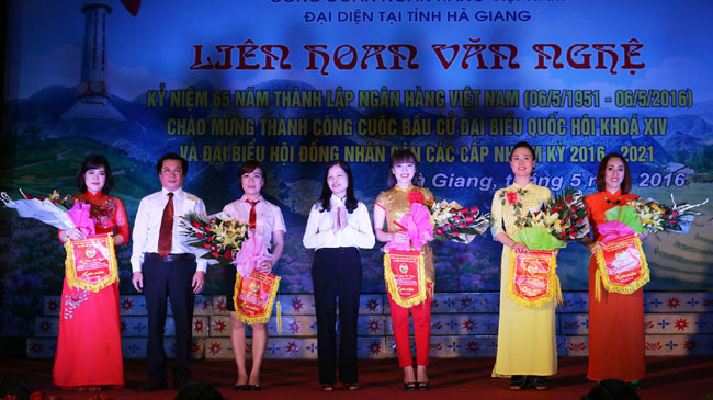 Đồng chí Nguyễn Xuân Thịnh, Tỉnh ủy viên, Giám đốc Ngân hàng Nhà nước tỉnh tặng cờ lưu niệm cho các đoàn tham dự văn nghệ.