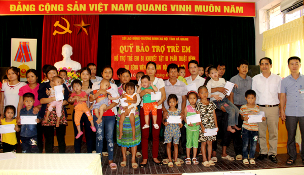 Đại diện Quỹ BTTE tỉnh tặng quà cho các cháu bị khuyết tật bẩm sinh được hỗ trợ trong đợt này. 