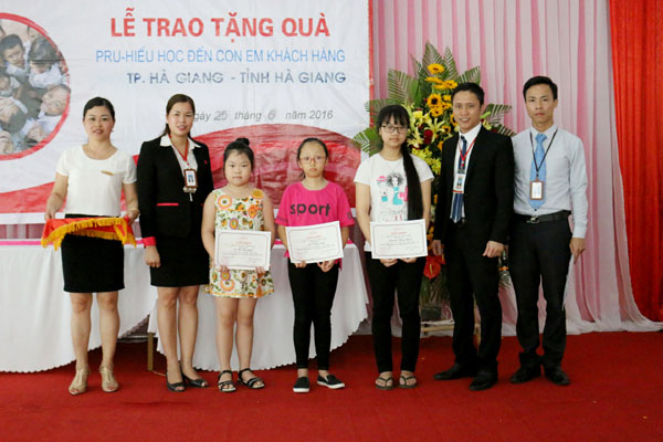 Đại diện Công ty Bảo hiểm nhân thọ Prudential Hà Giang trao giấy khen cho con em của khách hàng có thành tích xuất sắc trong học tập.