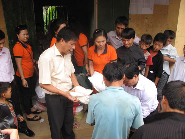 Đồng chí Lê Trọng Lập cùng các tình nguyện viên nhóm Thiện nguyện Hoa phượng đỏ trao quà cho các hộ nghèo trong thôn Thào Lủng