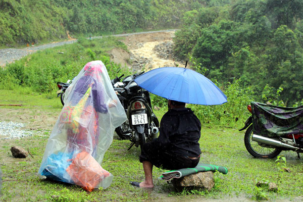 Một đôi vợ chồng ngồi chờ lũ ngớt.
