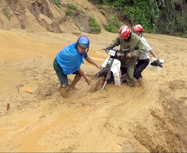 Người dân xã Thàng Tín lưu thông vất vả qua tuyến đường bị sạt lở đất. Ảnh: CTV