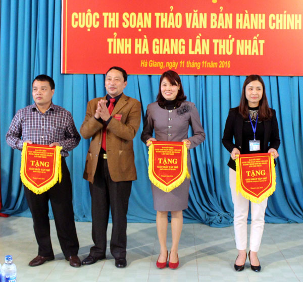 Ban tổ chức trao cờ cho 3 tập thể đạt giải Nhất trong cuộc thi soạn thảo văn bản hành chính tỉnh Hà Giang lần thứ nhất.
