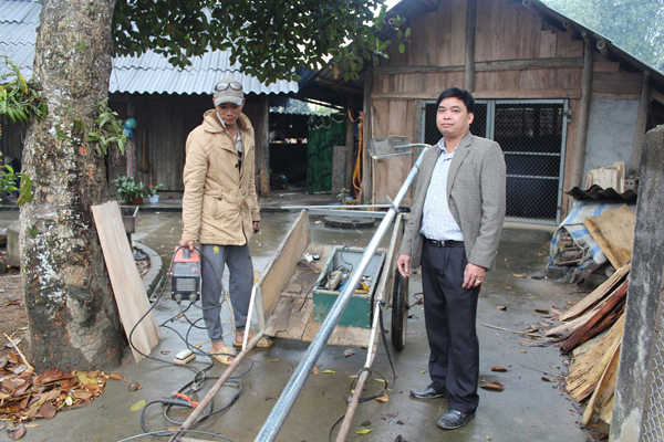 Ông Hoàng Minh Tuệ (bên phải) theo dõi việc lắp đặt các cột điện theo mô hình “Đèn thắp sáng an ninh trật tự” ở thôn Xuân Tịnh.