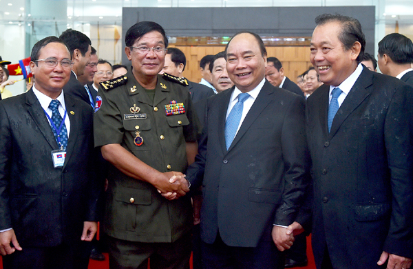 Thủ tướng Nguyễn Xuân Phúc, Phó Thủ tướng Thường trực Chính phủ Trương Hòa Bình đón Thủ tướng Vương quốc Campuchia Hun Sen trong điều kiện trời mưa khá lớn tại Bình Dương. Ảnh: VGP/Quang Hiếu