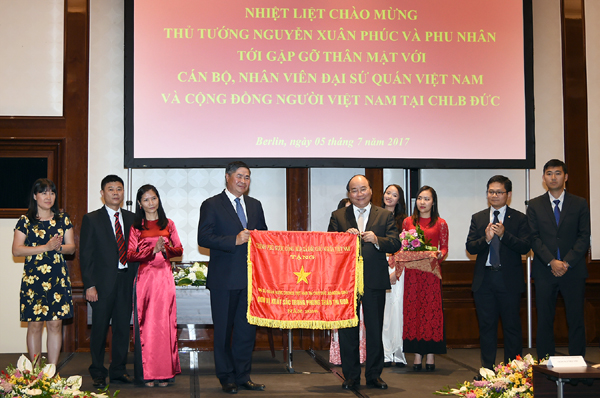 Thủ tướng Nguyễn Xuân Phúc tặng cờ thi đua của Chính phủ cho Đại sứ quán Việt Nam tại Berlin. Ảnh: VGP/Quang Hiếu