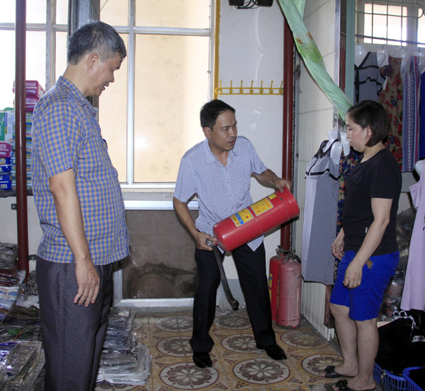 Cán bộ BQL chợ trung tâm TP Hà Giang hướng dẫn các hộ kinh doanh cách sử dụng bình chữa cháy.