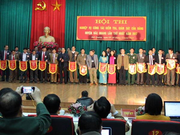: Đồng chí Lê Quang Minh, Ủy viên BTV Tỉnh ủy, Chủ nhiệm UBKT Tỉnh ủy cùng lãnh đạo huyện Bắc Quang tặng cờ lưu niệm cho các đội tham gia hội thi.