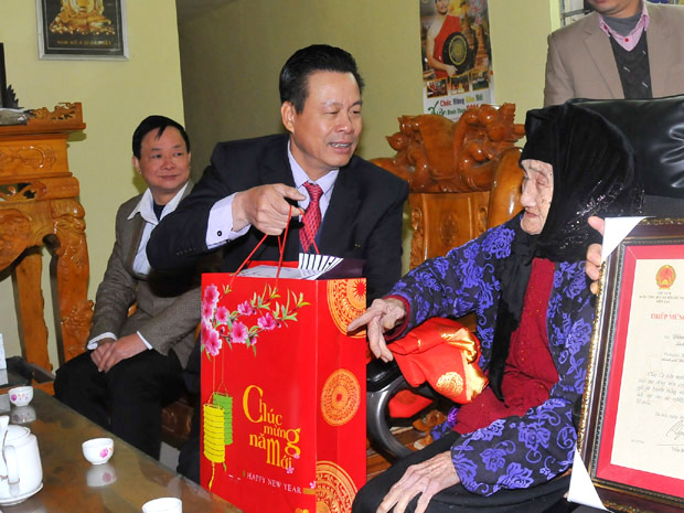 Thừa ủy quyền của Chủ tịch nước, Chủ tịch UBND tỉnh Nguyễn Văn Sơn tặng quà cho cụ Đinh Thị Nhường, 100 tuổi ở phường Trần Phú.