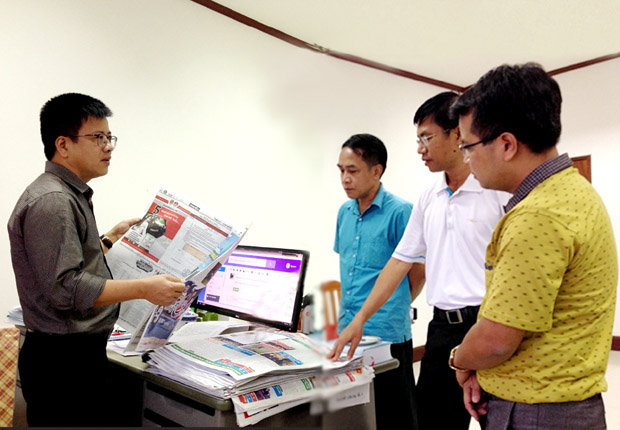 Đồng chí Nguyễn Trung Thu trao đổi nghiệp vụ với đồng chí SyvanhHomsdeth (áo trắng), Phó Tổng Biên tập Báo Nhân dân Lào.