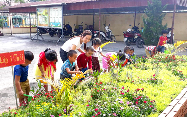 Giáo viên Trường Mầm non Thanh Vân (Quản Bạ) và học sinh trong giờ hoạt động ngoài trời.