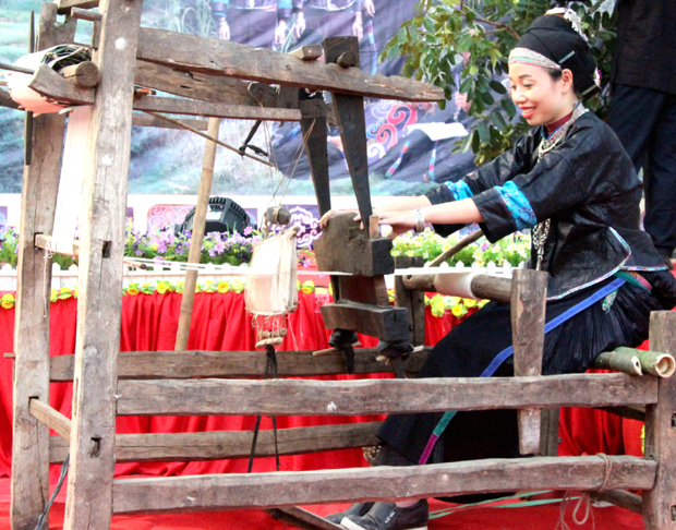 Phụ nữ dân tộc Nùng xe tơ, thêu trang phục truyền thống.