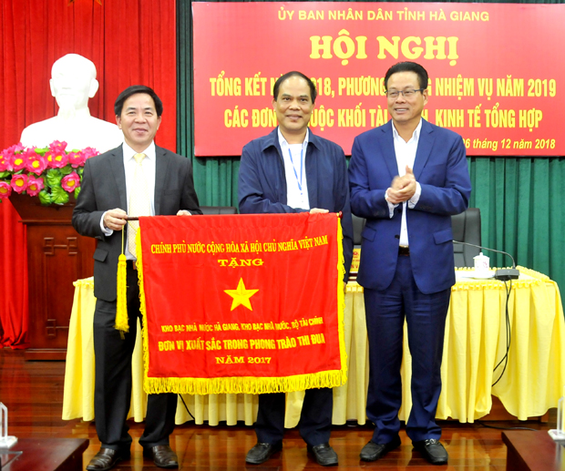 Thừa ủy quyền của Thủ tướng Chính phủ, Chủ tịch UBND tỉnh Nguyễn Văn Sơn trao Cờ thi đua cho Kho bạc Nhà nước tỉnh. 