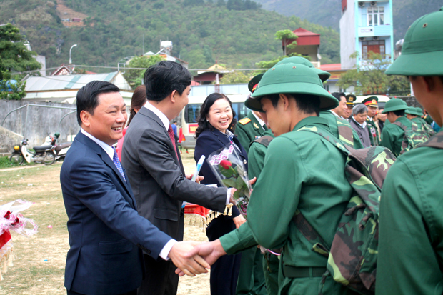 Đồng chí Nguyễn Minh Tiến, Phó Chủ tịch Thường trực UBND tỉnh và lãnh đạo huyện Yên Minh tặng hoa, động viên các tân binh.