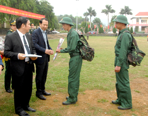 Các đồng chí lãnh đạo tỉnh, huyện tặng hoa và quà tiễn các tân binh lên đường nhập ngũ.