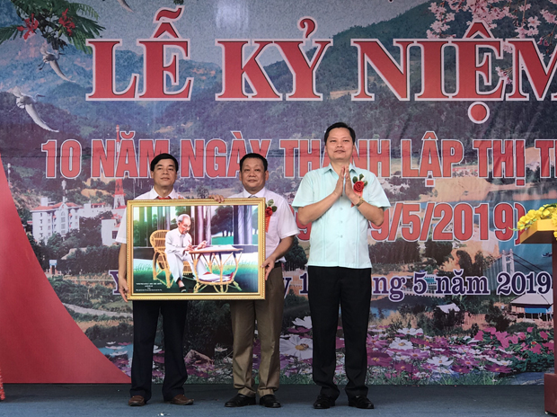 Đồng chí Bùi Văn Tuân, Bí thư Huyện ủy tặng Đảng bộ thị trấn bức tranh Bác Hồ tại buổi Lễ.