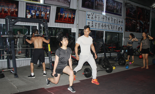 Anh Lừu Văn Chương (áo trắng) hướng dẫn học viên tập thể hình.