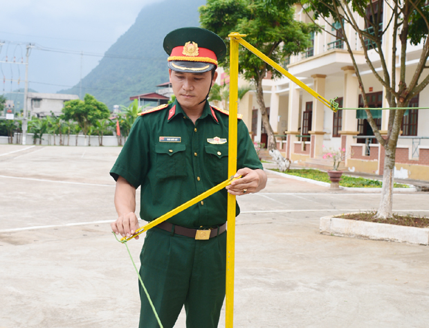 Thượng úy Trần Quốc Đạt giới thiệu mô hình cải tiến bộ cọc bổ trợ huấn luyện Điều lệnh đội ngũ tay không.        Ảnh: Văn Tuấn (Báo QĐND)