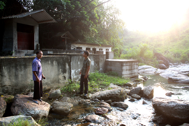 Ông Đặng Kim Lành (bên trái) giới thiệu về dòng suối khoáng Nậm Choong.