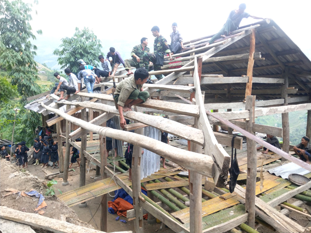 Cán bộ, chiến sỹ Đồn Biên phòng Xín Mần cùng nhân dân giúp hộ nghèo Lý A Ngò, thôn Đông Lợi, xã Nàn Xỉn làm nhà.                        Ảnh: Văn Long