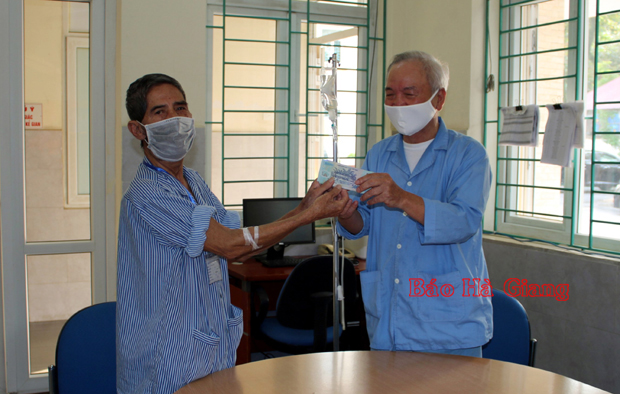 Ông Nguyễn Văn Nghị (bên phải) trao lại số tiền nhặt được cho Ông Lê Xuân Lụa. Ảnh: Nguyễn Việt Hà (Bệnh viện Đa khoa tỉnh)