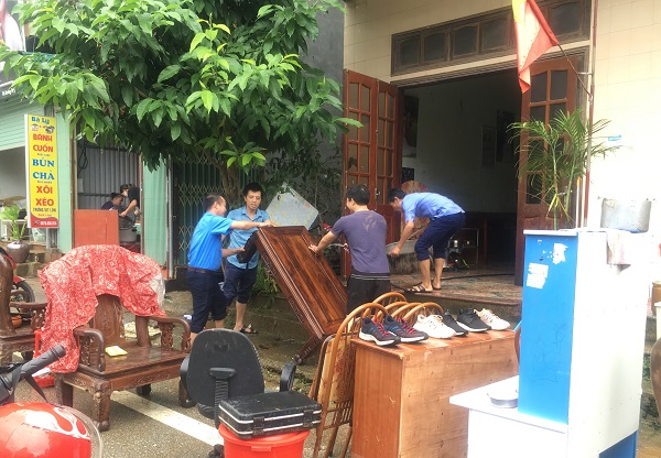 Nhân dân thị trấn Mèo Vạc dọn dẹp đồ đạc sau khi bị nước lũ tràn qua nhà.