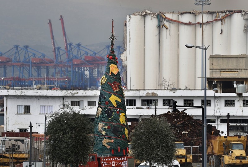 Người Lebanon trang hoàng cây thông Noel với đồng phục của lính cứu hỏa để tưởng nhớ những người đã thiệt mạng khi dập đám cháy kinh hoàng tại cảng Beirut trong tháng 8-2020. (Ảnh: AP)