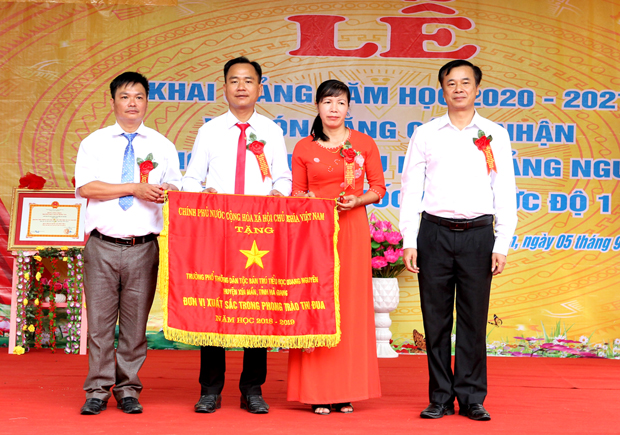 Bí thư Huyện ủy Xín Mần Hoàng Nhị Sơn trao Cờ thi đua xuất sắc của Thủ tướng Chính phủ cho Trường PTDT Bán trú Tiểu học Quảng Nguyên.
