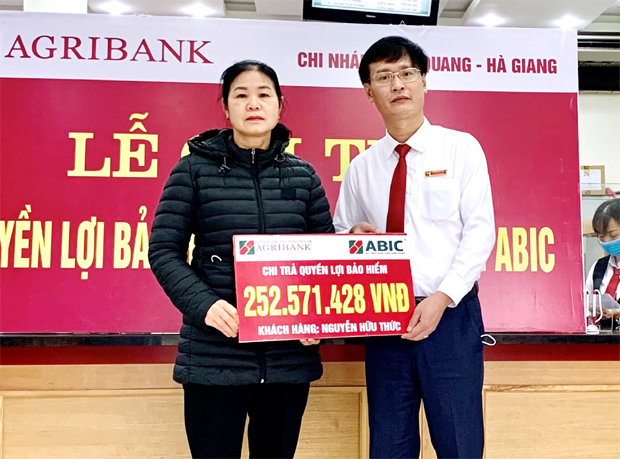  Ông Trương Đức Hào, Giám đốc Agribank Chi nhánh Bắc Quang chi trả quyền lợi Bảo an tín dụng cho gia đình ông Nguyễn Hữu Thức.