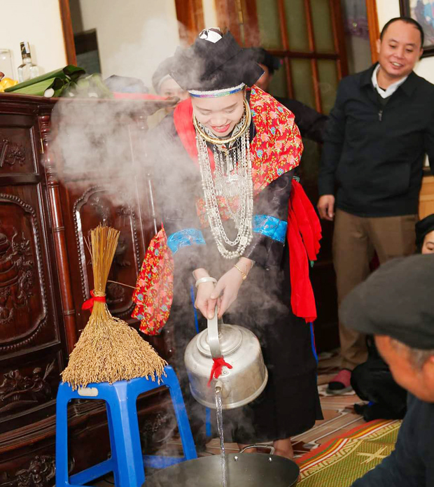 Cô dâu người Nùng thực hiện nghi thức đổ nước vào chảo khi về đến nhà trai trong ngày cưới.