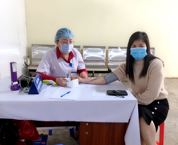 Cán bộ Trung tâm Y tế thành phố kiểm tra sức khỏe và khám sàng lọc cho các đối tượng tiêm vác xin Covid-19.