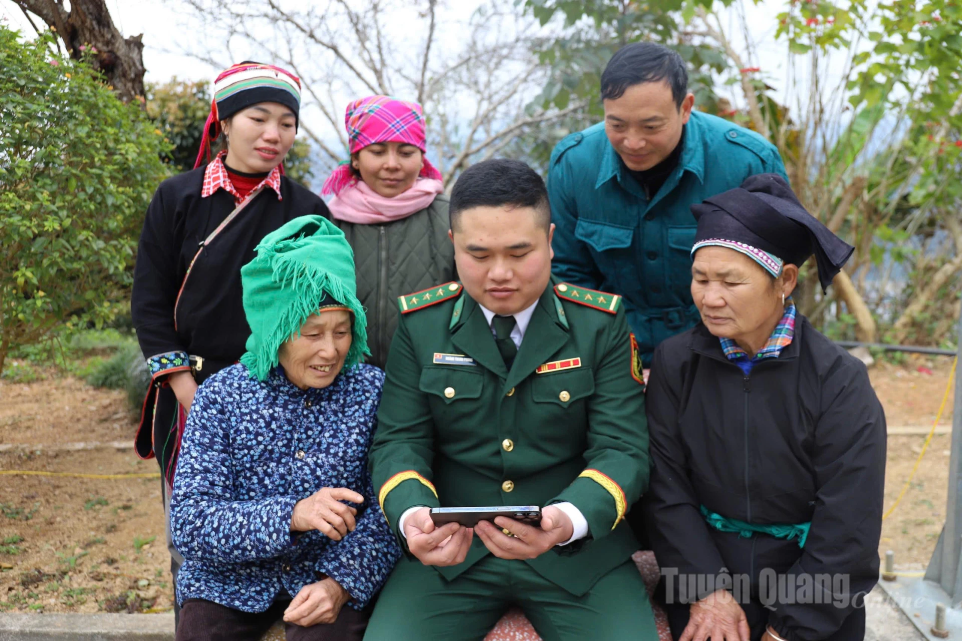 Cán bộ Đồn biên phòng Bạch Đích cùng người dân theo dõi bế mạc Đại hội qua điện thoại (Ảnh: My Ly)