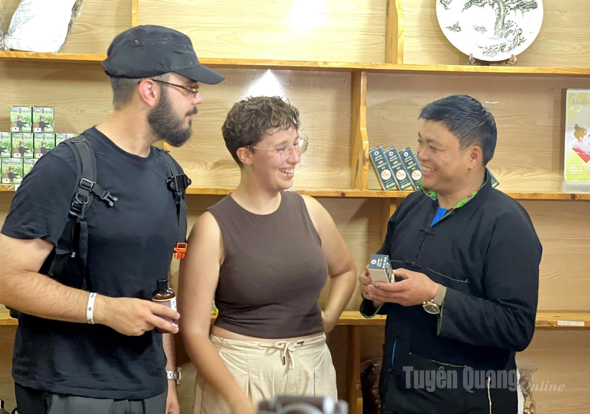 Giám đốc Hợp tác xã cộng đồng Nặm Đăm giới thiệu công dụng của dược liệu cho khách du lịch nước ngoài.