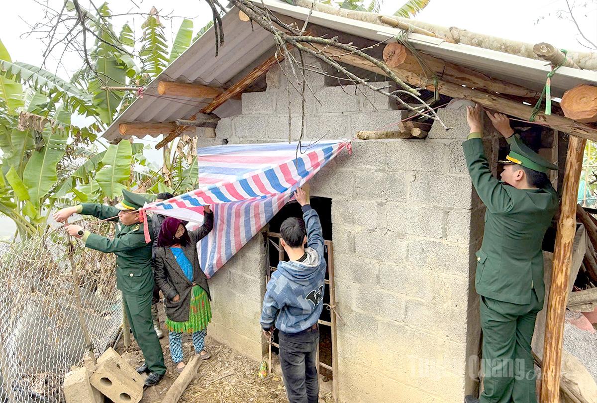 Cán bộ, chiến sĩ đồn biên phòng Sơn Vĩ giúp nhân dân trên địa bàn che chắn chuồng trại.