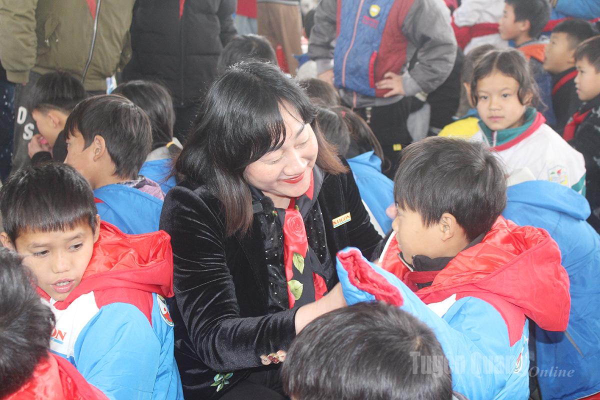Đồng chí Bùi Thị Hồng Sương, Phó Tổng Biên tập Báo SGGP trao áo ấm cho các em học sinh.