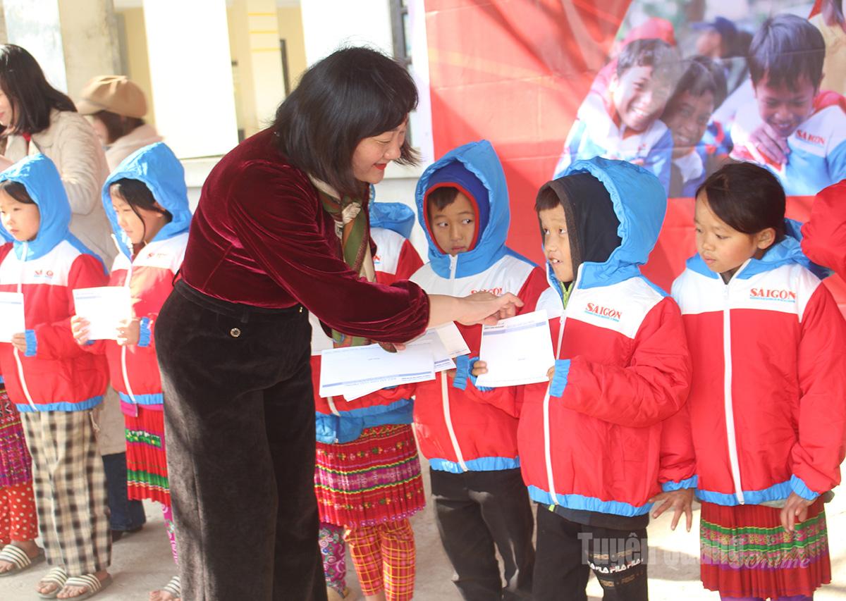 Đồng chí Bùi Thị Hồng Sương, Phó Tổng Biên tập Báo SGGP tặng áo ấm và học bổng cho các em học sinh Trường Phổ thông Dân tộc Bán trú Tiểu học Sơn Vĩ, xã Sơn Vĩ.